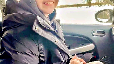 Smiling Asian student in black hoodie inside snowy taxi