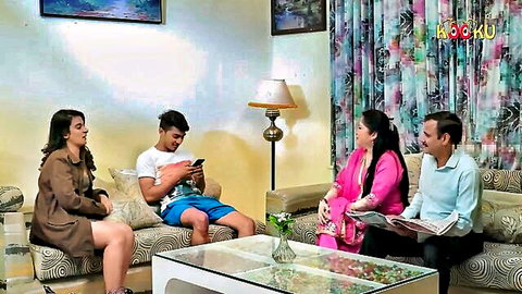 Indian teen guy in shorts sits with sexy stepsister and aunt uncle on couch chatting