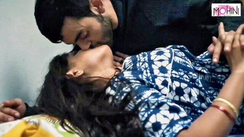 Indian couple passionately kissing on bed with man sucking woman's neck