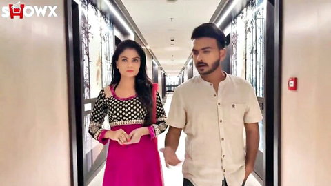Indian MILF beauty in pink dress walking with husband in hallway