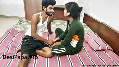 Desi Indian college couple holding hands intimately on bed