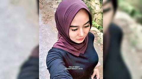 Southeast Asian Indonesian hijab girl in tight black top smiling for sexy outdoor selfie