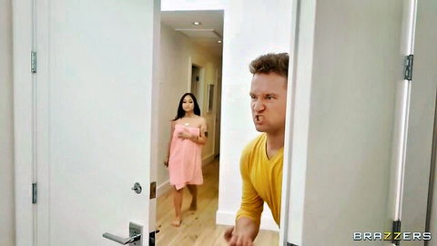Asian babe in short pink robe walks hallway as guy peeks playfully from door