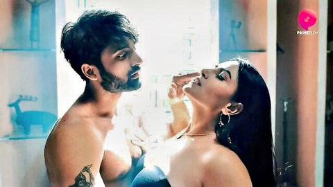 Intimate Indian couple in passionate embrace, man kissing woman's neck in lingerie