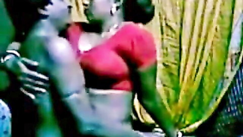 Indian maid in red saree embraced intimately by lover