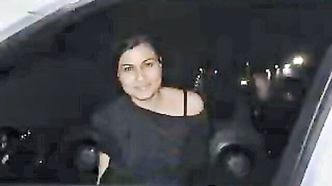 Dark-haired Italian beauty smiling in off-shoulder black top with cleavage in car at night