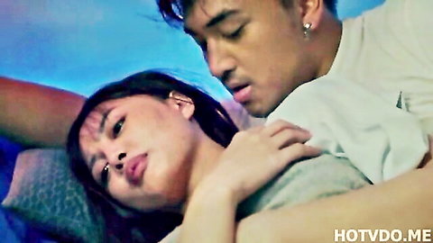 Filipino man passionately kissing woman's neck in intimate bed embrace
